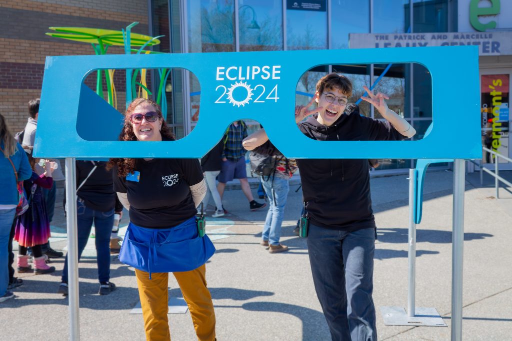 Staff smiling behind oversized Eclipse glasses outside ECHO in April 2024